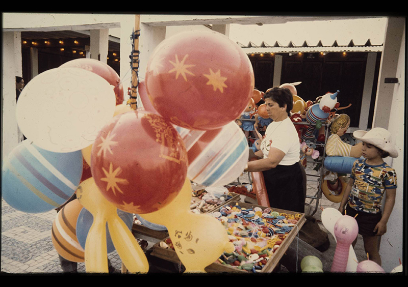 Festa comemorativa do 10 de Junho no Mercado do Povo: vendedora de balões junto ao Museu de Arte Popular. Ernesto de Sousa. 1921-1988, fotógrafo Direitos reservados. Reprodução mediante autorização do proprietário da imagem. Festa comemorativa do 10 de Junho no Mercado do Povo: vendedora de balões junto ao Museu de Arte Popular. Ernesto de Sousa. 1921-1988, fotógrafo Direitos reservados. Reprodução mediante autorização do proprietário da imagem.